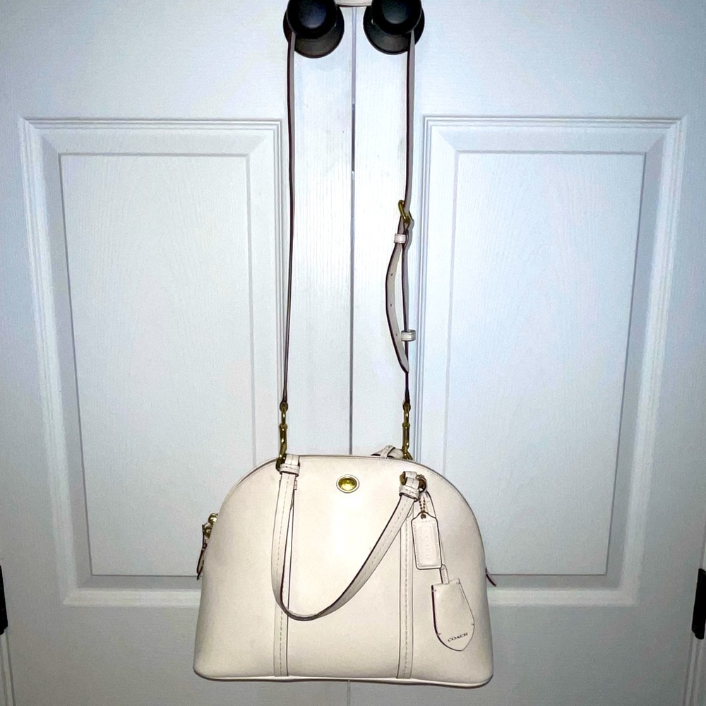 White coach bag with gold details.